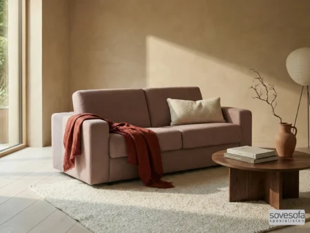 Gammelrosa Hovden sovesofa, modell Bedinside med brede armlener, i et lyst og minimalistisk miljø.
