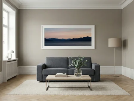 Elegant stue med en Hovden Bedinside sovesofa med Ambassadør armlener, plassert under et stort kunstverk.