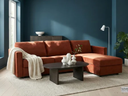 Oransje velour sovesofa vist mot en petrolium-farget vegg for å skape en spennende og moderne fargekontrast